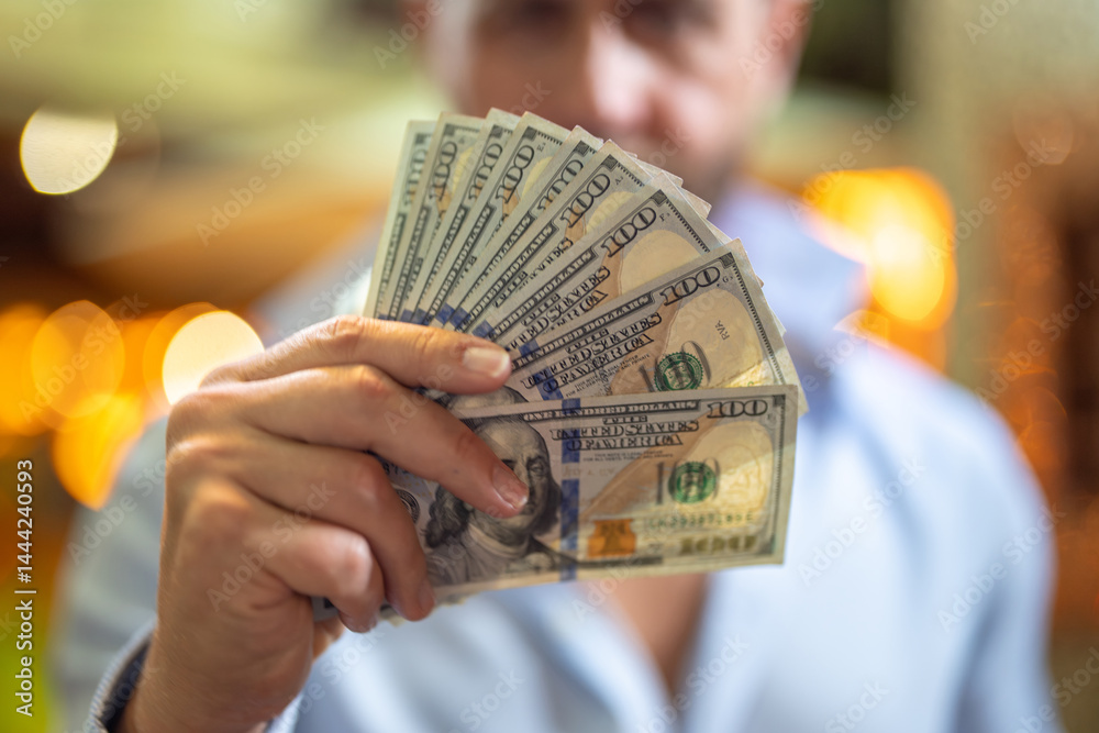 Rich businessman holding cash. Successful rich man counting dollar bills. Rich business man with dollar bills. Wealthy man showing dollars money. Rich man holding banknotes. Financial success. Riches.