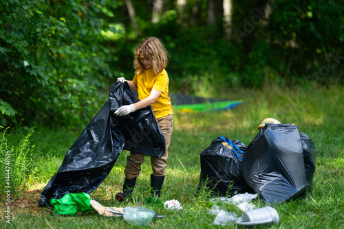 Obraz na płótnie Child picking plastic trash for cleaning the nature. kid Clean up garbage outdoor. Ecology concept. Environment Day. Save earth. Recycling bin garbage. Ecology. Environmental care. Eco kid. w salonie