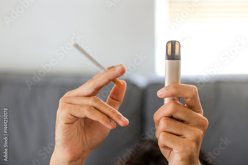 Man holding a cigarette and e-cigarette vaping device. Quitting smoke concept.