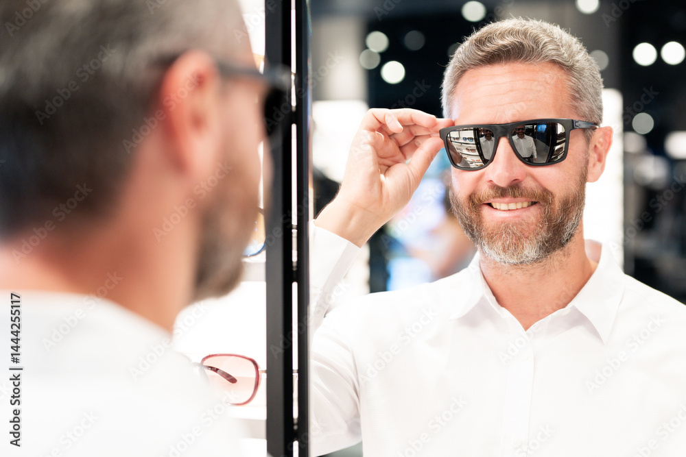Sunglasses mature model in fashion store. Fashionable middle-aged man. Trendy sunglasses accessories for men. Eyewear sunglasses collection. Fashion look with sunglasses. Fashion eyewear.