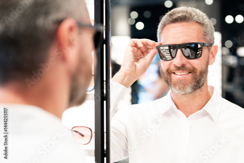 Obraz na płótnie Sunglasses mature model in fashion store. Fashionable middle-aged man. Trendy sunglasses accessories for men. Eyewear sunglasses collection. Fashion look with sunglasses. Fashion eyewear. w salonie