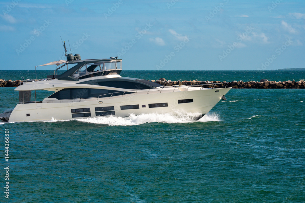 Yacht sailing on sea waters. Luxury superyacht at sea. Miami Beach with yachts. Seascape with a sailboat. Cruise ship near the coastline. Sunset yacht voyage. Luxury sailboat yacht. Boating.