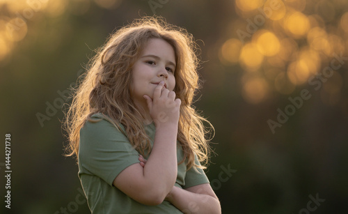 Obraz na płótnie Kid looking away and thinking. Child dreamer thinking with a doubtful look. Portrait of a child thinking deeply. Dreamy teen child lost in thinking. Clever boy with thoughtful face. Daydreaming kid. w salonie