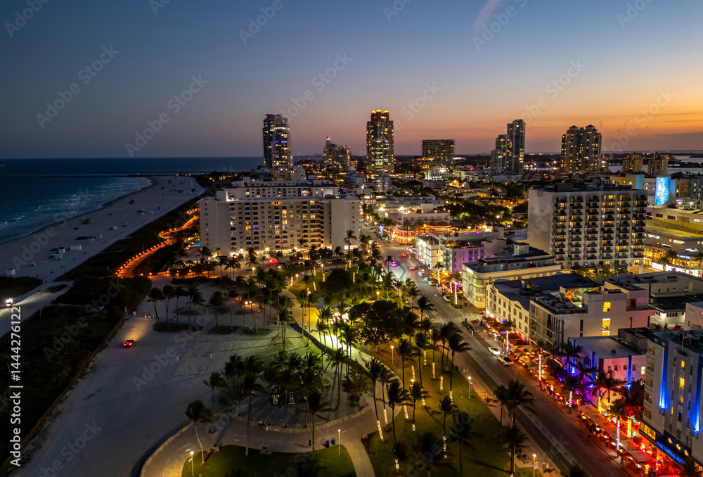 Miami skyline with ocean view. Sunset over South Florida beaches. Drone view of cityscape. Illuminated Miami skyline at night. Panoramic night of Miami waterfront. Famous landmarks of Miami Beach.