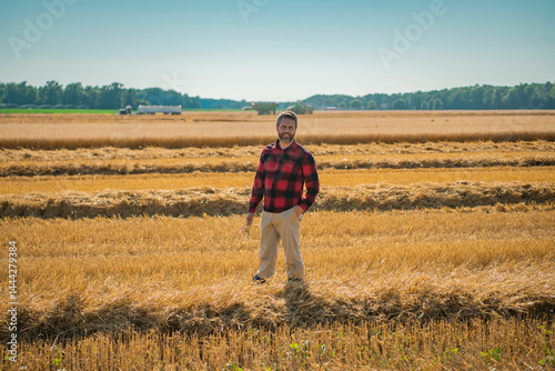 Obraz na płótnie The harvest. Man working on farm field. Farming in the countryside. Farm landscape with farmer man on field. Farmer man harvesting ripe barley. Man checking the harvest. Farmer inspecting the harvest. w salonie
