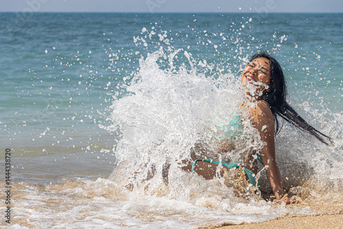 Obraz na płótnie Sea waves crashing against a woman in a bikini w salonie