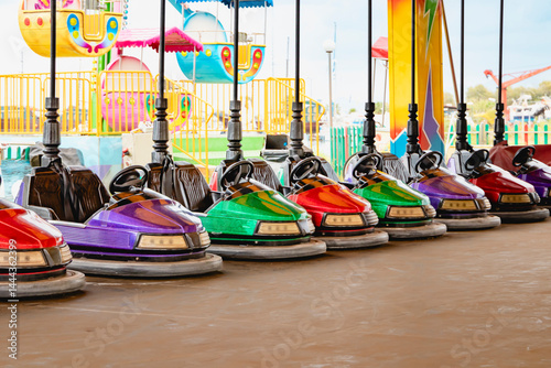 Obraz na płótnie Colorful bumper cars are lined up at a vibrant amusement park, inviting thrilling excitement and joy at the amusement park w salonie