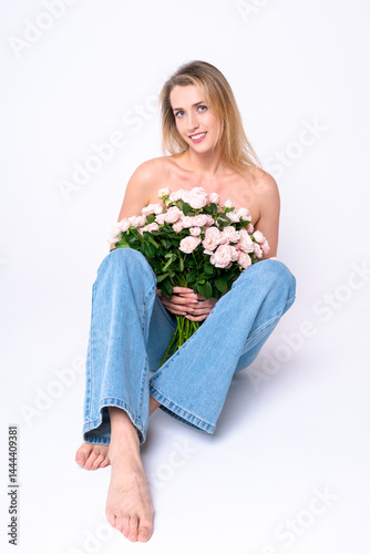 Stylish barefoot woman in jeans with a bouquet of pastel roses. Symbol of femininity, natural beauty and minimalist harmony