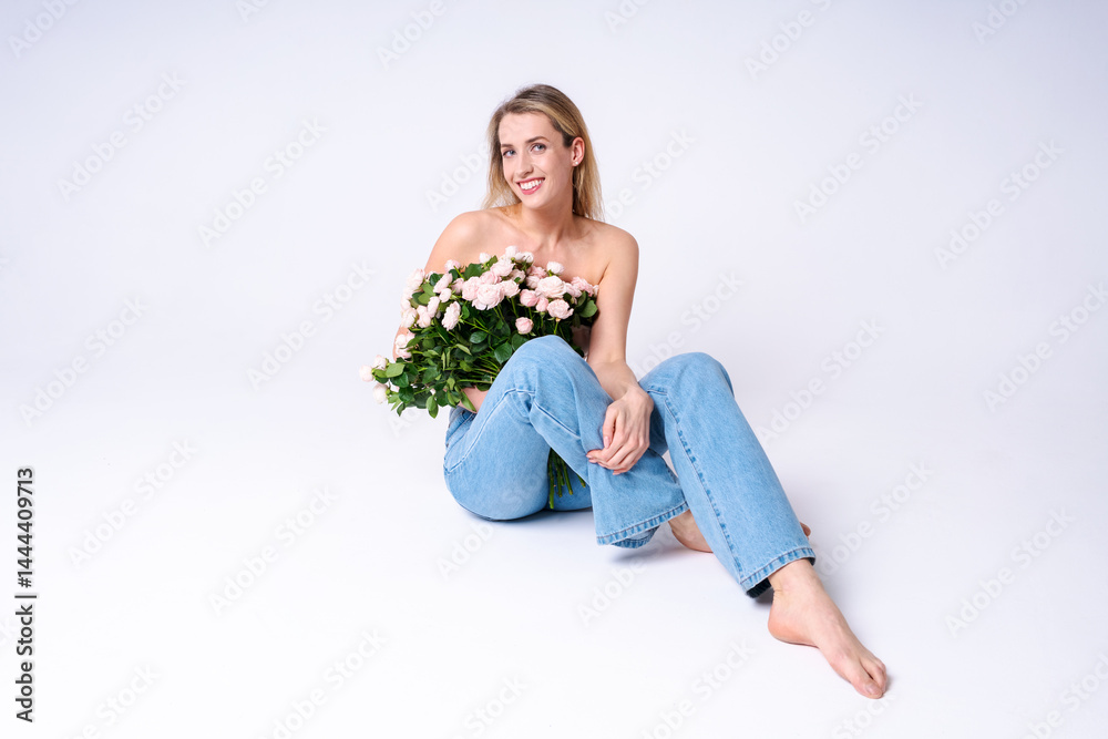A tender young woman in jeans and a shirt with flowers in the studio, natural beauty, lightness and romance for advertising and lifestyle content