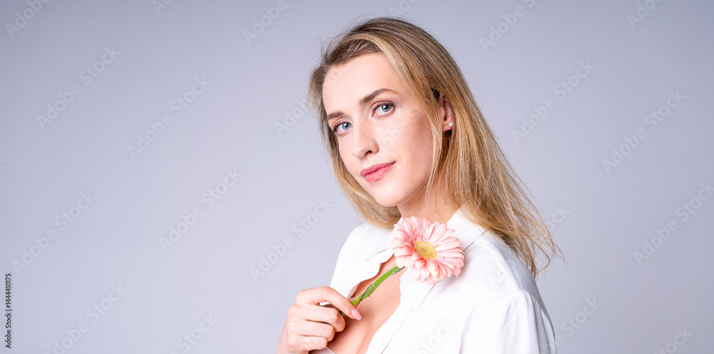 Young woman with flower on light background, ideal for beauty, style and naturalness concepts