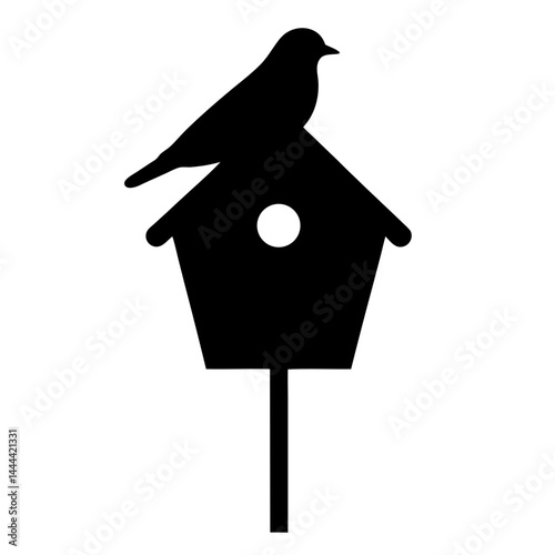 Silhouette of a bird perched atop a classic birdhouse design