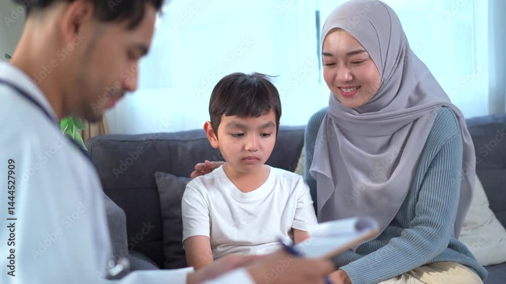 Asian Muslim mother takes her 5–10 year old sick son to see a doctor at the hospital. Asian Muslim mother takes her 5–10 year old sick son to see a doctor at the hospital.