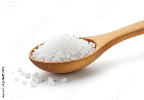 A wooden spoon filled with white crystalline substance on a white surface in a close up view shot