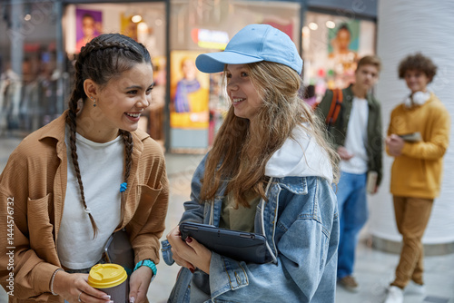 Obraz na płótnie Teenage girls friends gossiping, talking and laughing together in shopping mall w salonie