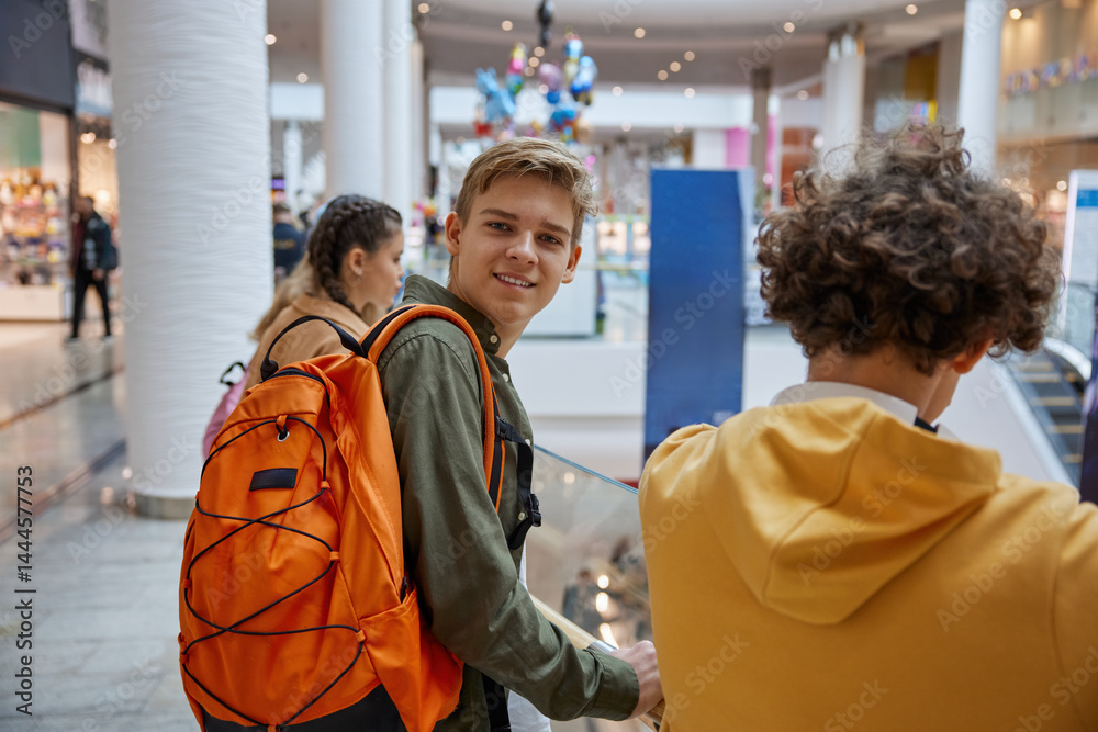 Excited teenage boy looking at camera while entertaining at shopping center