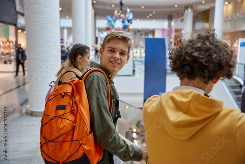 Obraz na płótnie Excited teenage boy looking at camera while entertaining at shopping center w salonie
