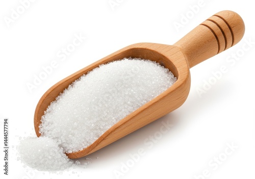 A wooden scoop filled with white granulated sugar sitting on a white surface in a studio shot