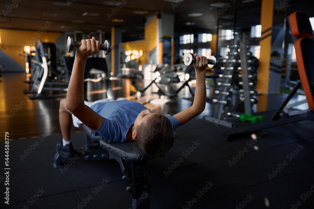 Overhead view portrait of teenage boy training with dumbbells