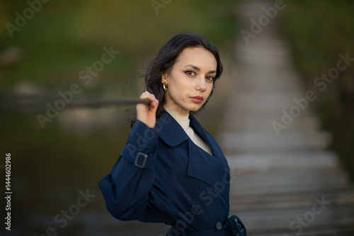 Obraz na płótnie beautiful brunette european girl in blue trench coat at nature. Young lady with beautiful face. w salonie