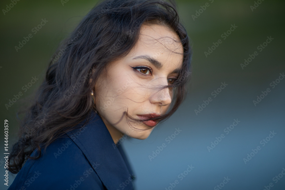 beautiful brunette european girl in blue trench coat at nature. Young lady with beautiful face.