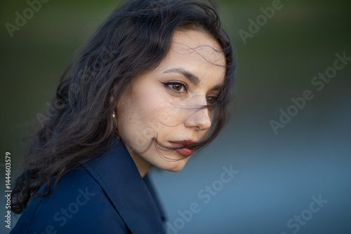 Obraz na płótnie beautiful brunette european girl in blue trench coat at nature. Young lady with beautiful face. w salonie