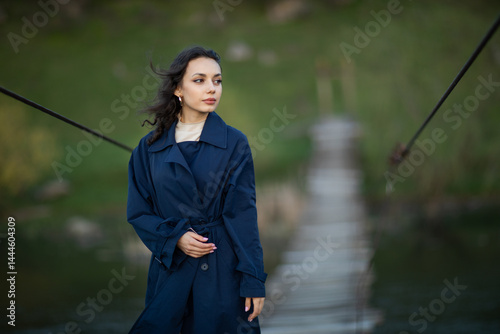 Obraz na płótnie beautiful brunette european girl in blue trench coat at nature. Young lady with beautiful face. w salonie