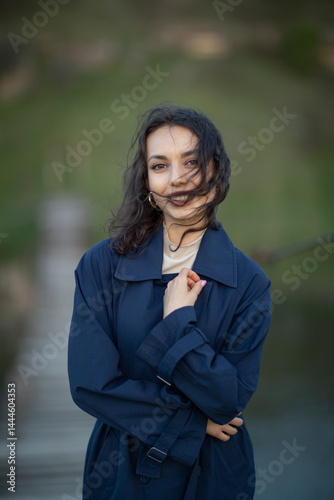 Obraz na płótnie beautiful brunette european girl in blue trench coat at nature. Young lady with beautiful face. w salonie