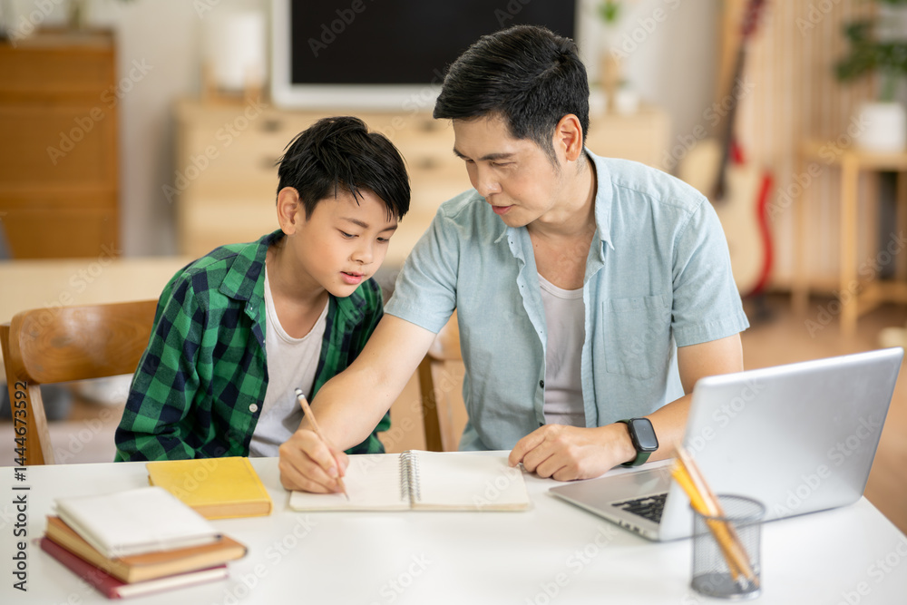 The father is teaching his son his homework with care at his home. The father is teaching his son his homework with care at his home.