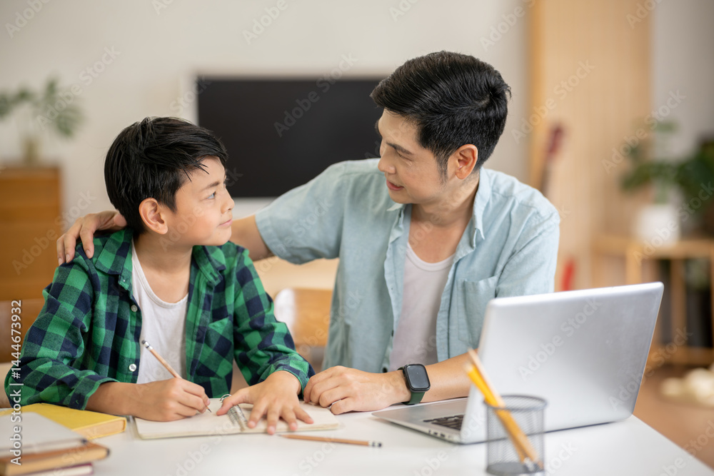 The father is teaching his son his homework with care at his home. The father is teaching his son his homework with care at his home.