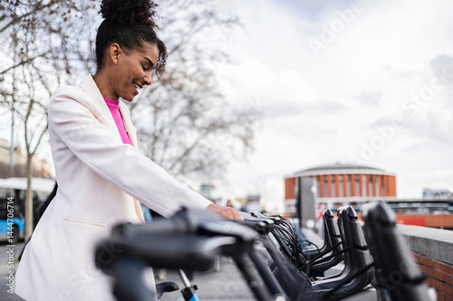 Woman in business attire smiling while selecting an e-bike outdoors