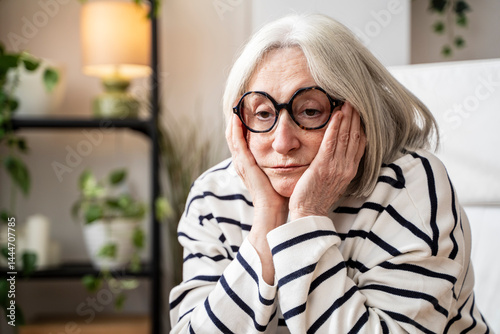 Thoughtful woman with white sitting with head in hands looking despaired