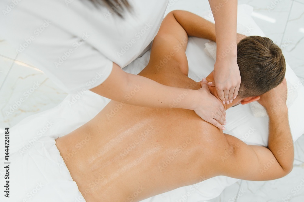 A man getting a back massage lying down at spa A man getting a back massage lying down at spa