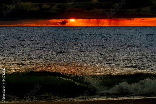 Obraz na płótnie Very moody and dramatic sky over the cloudy ocean horizon, with strong orange, sunbeams and traces of lingering storm cells w salonie