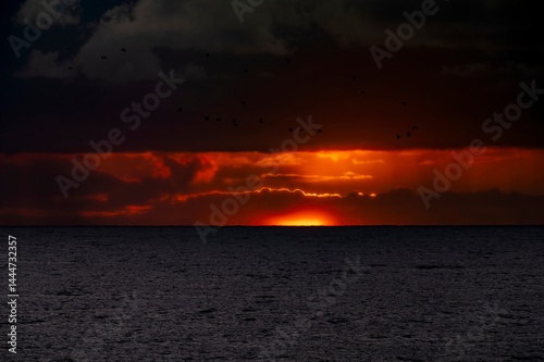Obraz na płótnie Very moody and dramatic sky over the cloudy ocean horizon, with strong orange, sunbeams and traces of lingering storm cells w salonie