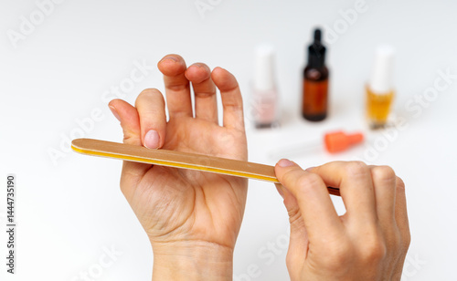 Close-up of woman using an emery board for nail care.