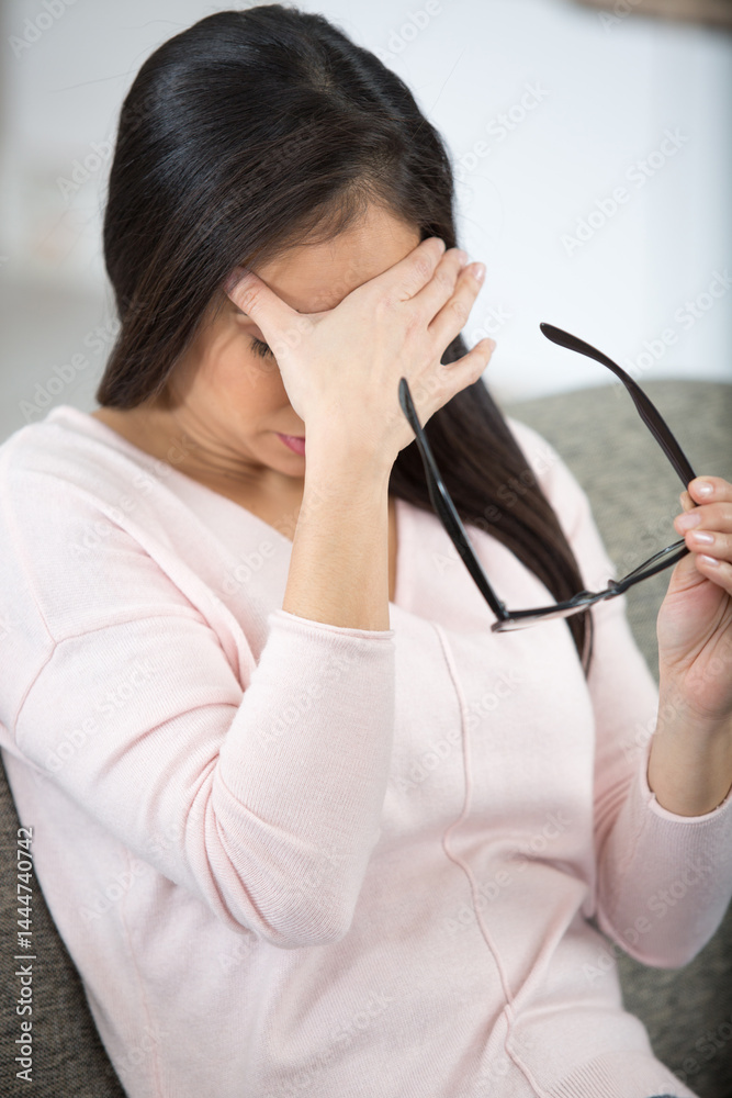 tired woman taking off glasses