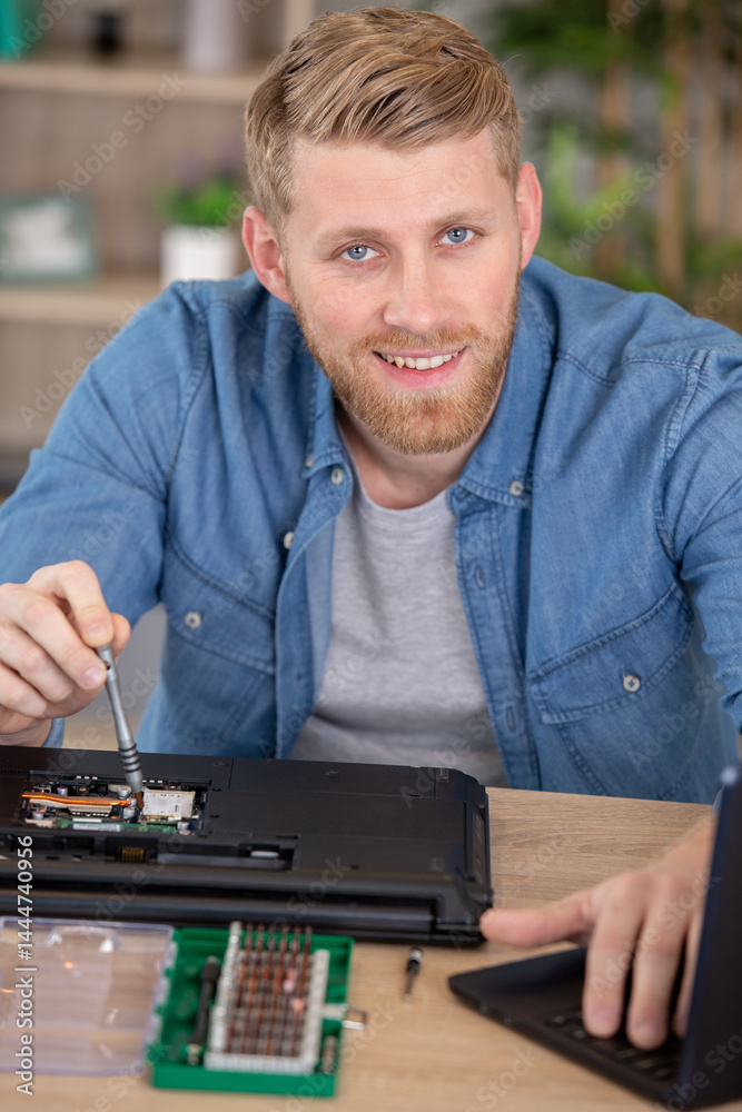 man repairing laptop computer at workshop