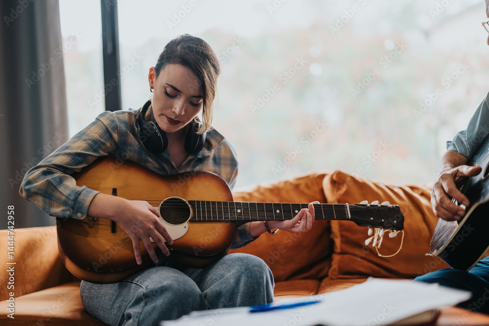 An elderly professor guides a young student in playing guitar during a music class, fostering musical education and creative exchange within a school environment.