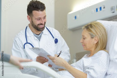 Obraz na płótnie doctor talks to patient in hospital bed w salonie