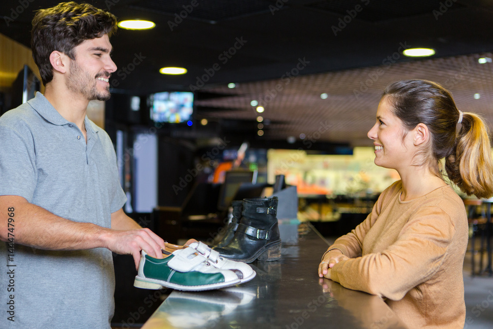 woman borrowing a pair of bowling shoes