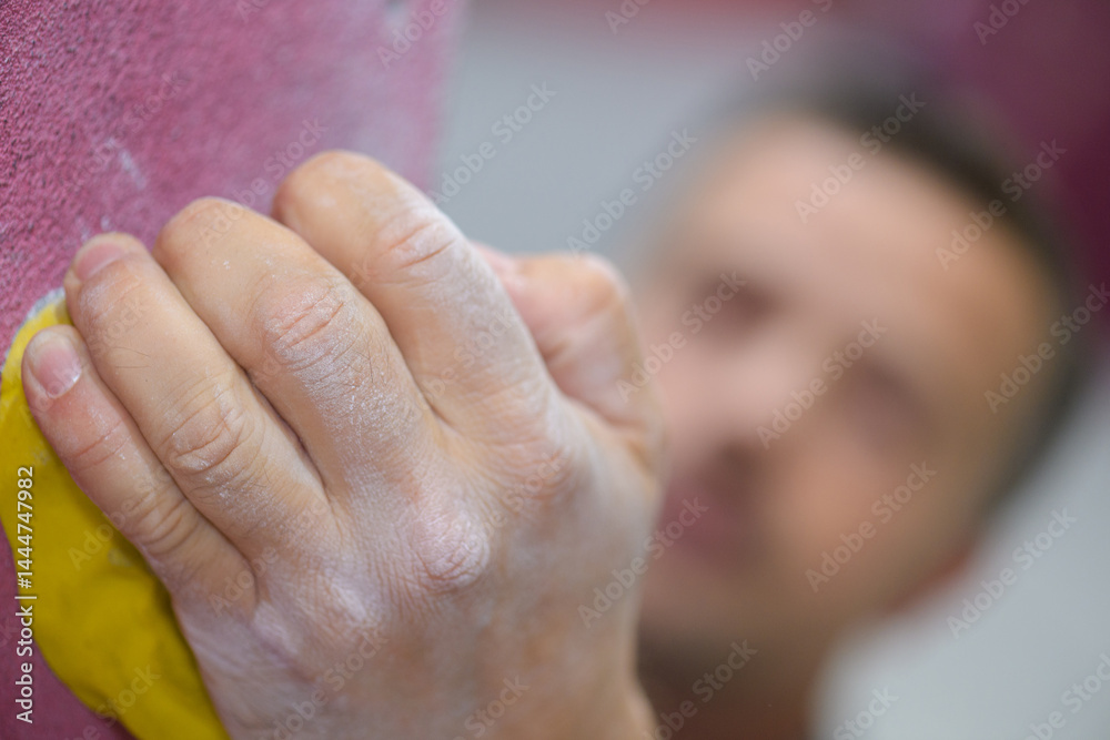hand holds a stone on the rock climbing wall