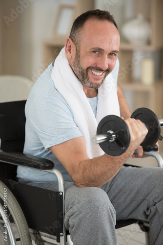 Obraz na płótnie involved disabled man exercising with dumbbells w salonie