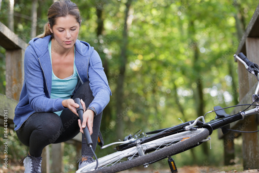 woman repairing mountain bike outdoors