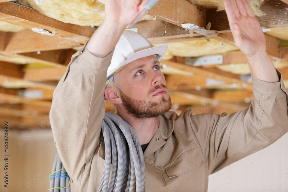 worker in the attic connects air ducts