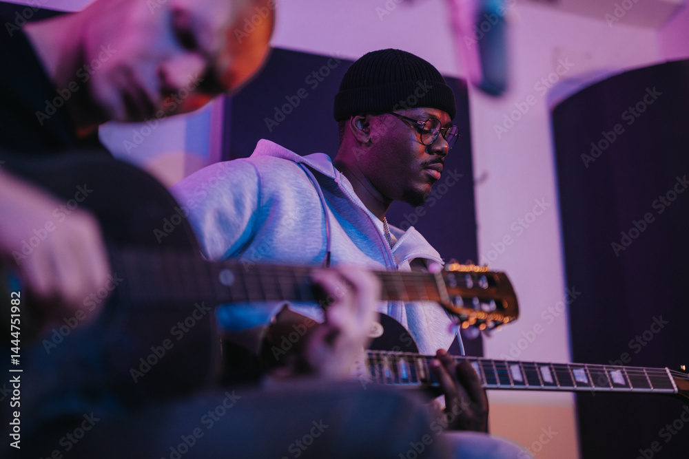Two guitarists engrossed in a recording studio session, playing acoustic music with passion and concentration.