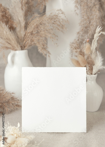 Obraz na płótnie Blank card near dry beige pampas grass on linen closeup, mockup. Bohemian wedding stationery w salonie