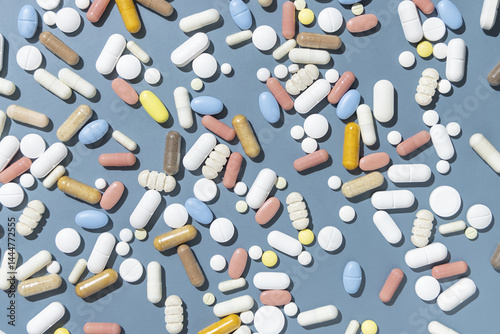 Obraz na płótnie Pile of mixed white, yellow and blue medical capsules and pills on blue top view w salonie