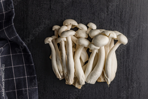 Obraz na płótnie Raw white shimeji mushrooms on black table. Top view. w salonie