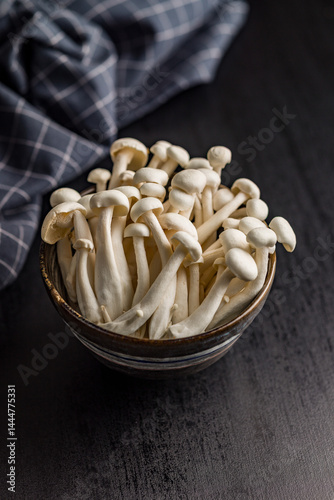 Obraz na płótnie Raw white shimeji mushrooms in bowl on black table. w salonie