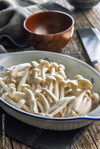 Obraz na płótnie Raw white shimeji mushrooms in bowl on cutting board. w salonie